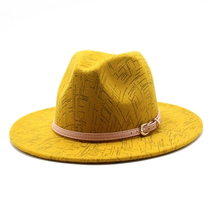 Detail of yellow wool fedora hat featuring black linear patterns and a buckle leather band