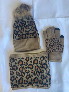Close-up of leopard print knitted hat with faux fur pom pom, scarf and touch screen gloves