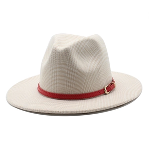 Detail of wool fedora hat with houndstooth texture and red leather band with gold buckle