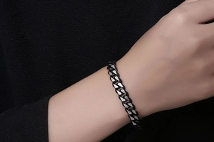 Détail d'un bracelet gourmette en acier inoxydable noir mat et argent pour homme
