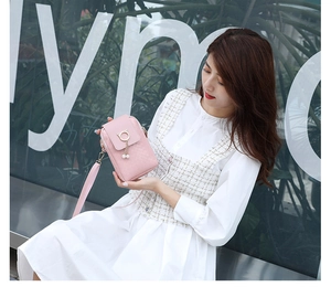 Detailed view of pink woven PU leather phone bag with cat metal clasp and pearl tassel