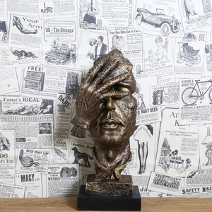 Abstract creative resin sculpture in bronze finish showing a person covering eyes