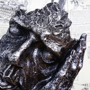 Abstract silver-black face sculpture on vintage newspaper background for home decor