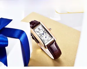 Detailed macro view of rectangular watch dial with Roman numerals and blue cabochon crown