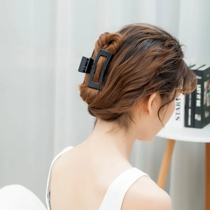 Matte black rectangular hair claw clip styling on brunette wavy hair for daily look