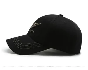 Detail view of black baseball cap featuring golden WOLF embroidery and yellow brim stitching