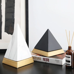 Modern ceramic pyramid ornaments with marble texture and gold base on books