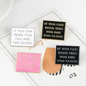 Enamel brooch with 'IF YOU CAN READ THIS YOU ARE TOO CLOSE' phrase in three colors
