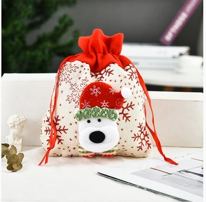 Close-up of beige Christmas drawstring gift bag with a 3D polar bear and red snowflakes