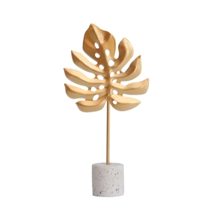 Modern gold monstera leaf decor with marble base for minimalist home office styling