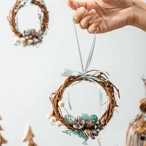 Handmade Christmas rattan wreath featuring blue bow, pine cones, and white berries decoration