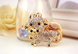 Dettaglio portachiavi a forma di mucca dorata con strass scintillanti e finiture di lusso