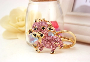 Dettaglio portachiavi a forma di mucca con cristalli rosa e placcatura in oro