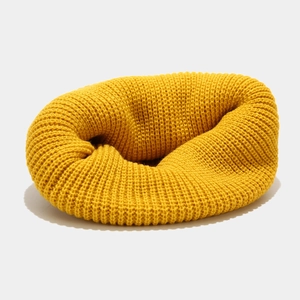 Detail of ginger yellow knitted infinity scarf with thick ribbed texture for winter warmth