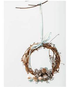 Detail of handmade woven rattan wreath with pine cones and decorative blue ribbon bow