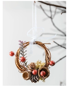 Detailed close-up of a rustic Christmas wreath with red berries, pine cones and white ribbon