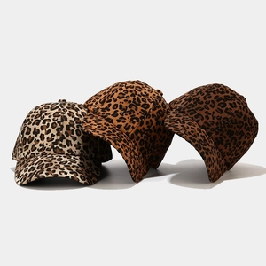 Tre cappellini da baseball con stampa leopardata in beige e marrone su fondo grigio