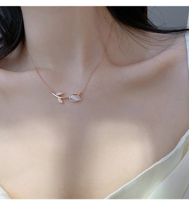 Close-up of rose gold flower pendant necklace with opal stones worn on neck