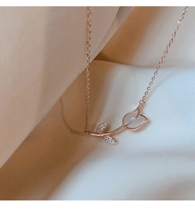 Detail of rose gold tulip pendant with opal petals and micro-set diamonds on beige silk