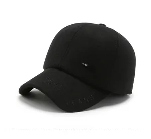 Close-up of black winter baseball hat showing embroidered JEANS logo and metal side badge