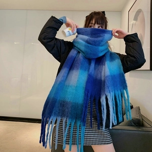 Detail of blue-grey gradient checkered scarf with thick fringe on a model wearing black