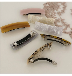 Flat lay of multiple acetate hair clips in marble and tortoiseshell patterns