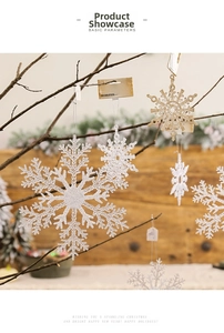 Sparkling snowflake ornaments in gold and silver hanging on tree branches for Christmas decor