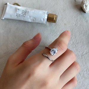 Close-up of a 925 silver ring featuring a pear-cut zircon on a minimalist background