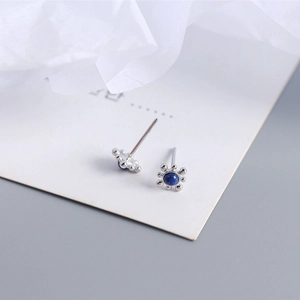 Detailed shot of sterling silver lapis lazuli stud earrings on a white card display