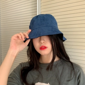 Detail view of navy blue faux suede flat top bucket hat worn by a model in casual style