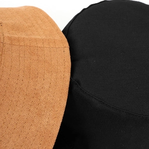 Detailed close-up of premium suede and twill fabric texture on a flat-top bucket hat