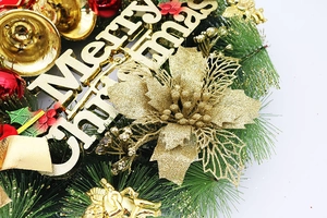 Gros plan de la plaque Merry Christmas avec anges dorés et cloches sur la couronne
