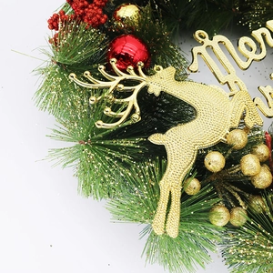 Close-up of Christmas wreath with pine needles, red berries and golden Merry Christmas sign