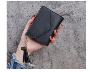 Detail of black pebbled leather wallet with heart pendant and tassel charm