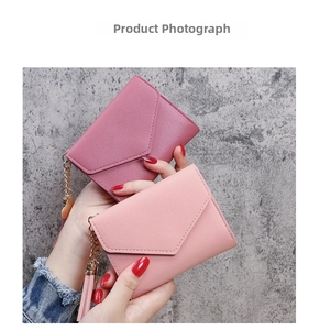Detail of pink lychee textured PU leather wallets with tassels and gold chains