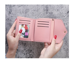Detail of pink faux leather tri-fold wallet showing interior card slots and photo window