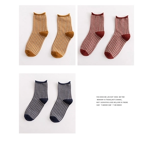Three pairs of vintage plaid cotton socks in ginger, burgundy, and navy with rolled cuffs