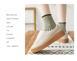 Detailed view of women's vintage green plaid cotton socks paired with platform sneakers