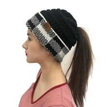 Detail of black knit ponytail beanie with black and white checkered cuff and CC leather patch