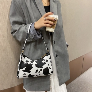 Chic cow print baguette bag for women with black trim and gold-tone zipper for daily use