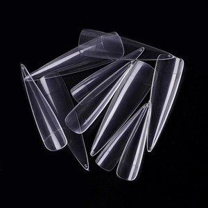 Set of clear stiletto false nail tips in various sizes on a black background