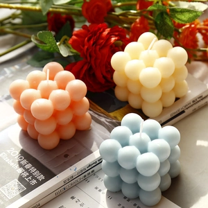 Tre candele a bolla color pastello rosa, bianco e blu, disposte come decoro per la casa