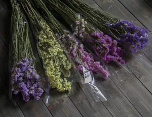 Dried yellow and purple forget-me-not flower bouquets on a rustic wood floor