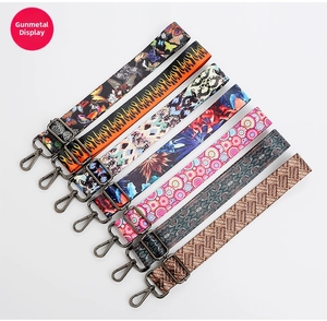 Detail of adjustable patterned shoulder straps with gunmetal hardware for handbags