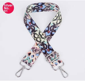 Detail of adjustable ethnic pattern bag strap with silver metal hooks and buckle