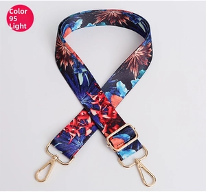 Detail of adjustable bag strap with blue floral pattern and gold metal lobster clasp