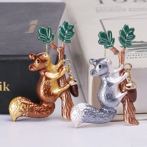 Charming enamel squirrel pins with green leaves and acorns on a modern background