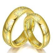 Macro shot of gold wedding bands featuring walnut wood inlay and engraved Elvish script
