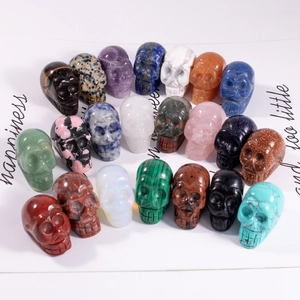 Collection of carved natural stone mini skulls in amethyst lapis and tiger eye crystals