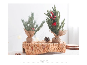 Mini sapins de Noël avec baies rouges et base en toile posés sur un socle rustique